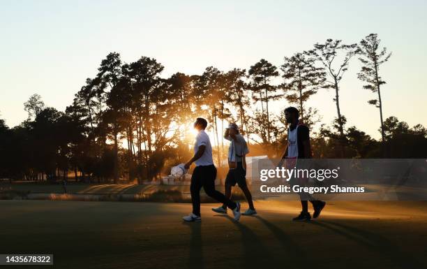 Jon Rahm of Spain, Kurt Kitayama of the United States and Cameron Davis of Australia walk on the 18th green during the third round of the CJ Cup at...