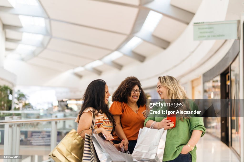 Mulheres felizes interagindo no shopping