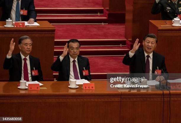 Chinese President Xi Jinping, right, Premier Li Keqiang, centre, and Politburo member Wang Yang raise their hands as they vote during the closing...