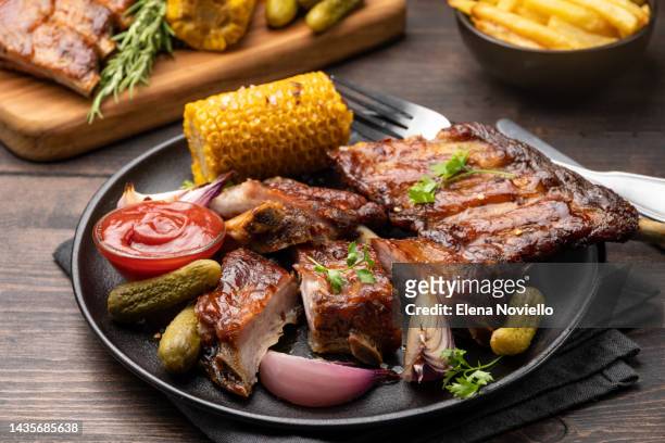 spare ribs grilled ribs with barbecue sauce and ketchup and grilled vegetables - rib food stock pictures, royalty-free photos & images
