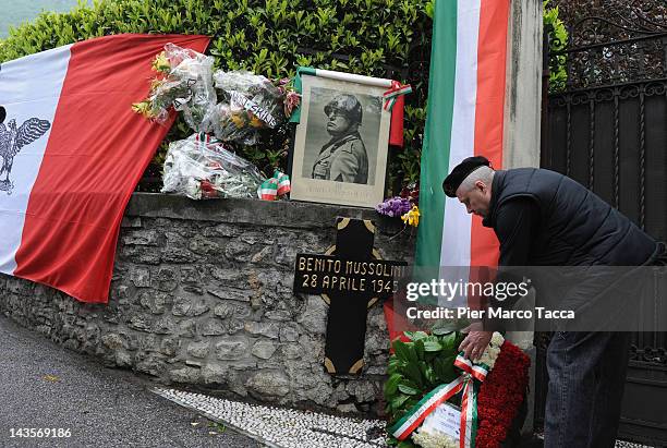 Man attends a commemoration ceremony for the death of Italian dictator Benito Mussolini and his mistress, Claretta Petacci in front of a headstone of...