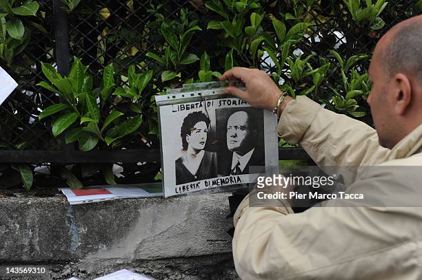 Man attends a commemoration ceremony for the death of Italian dictator Benito Mussolini and his mistress, Claretta Petacci in front of a headstone of...