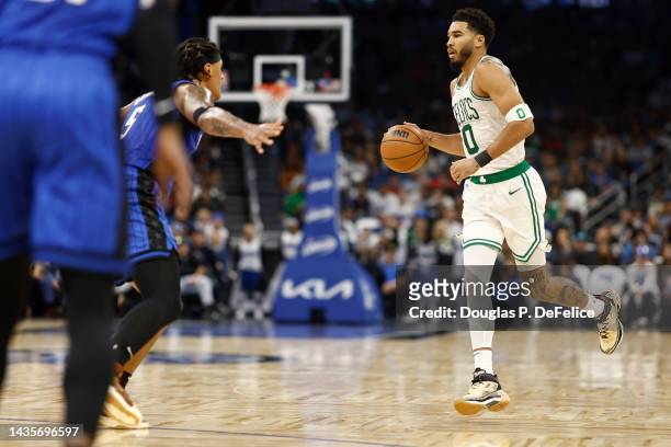 Jayson Tatum of the Boston Celtics handles the ball as Paolo Banchero of the Orlando Magic defends during the second quarter at Amway Center on...