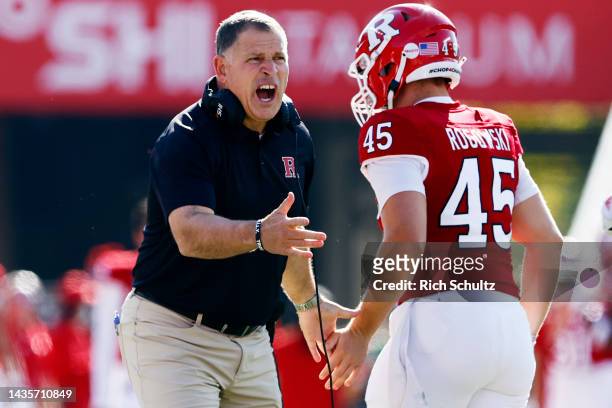 Head coach Greg Schiano of the Rutgers Scarlet Knights congratulates Ed Rogowski after a play during the fourth quarter of a college football game...
