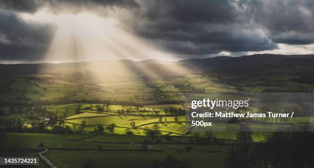 sunlight shining on small town in green landscape,bampton grange,penrith,united kingdom,uk - 坎布里亞 個照片及圖片檔