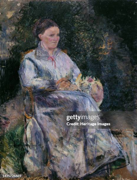 Julie Pissarro au jardin, circa 1874. Julie Pissarro in the garden. Julie Pissarro , wife of the artist, with sewing basket. Artist Camille Pissarro.