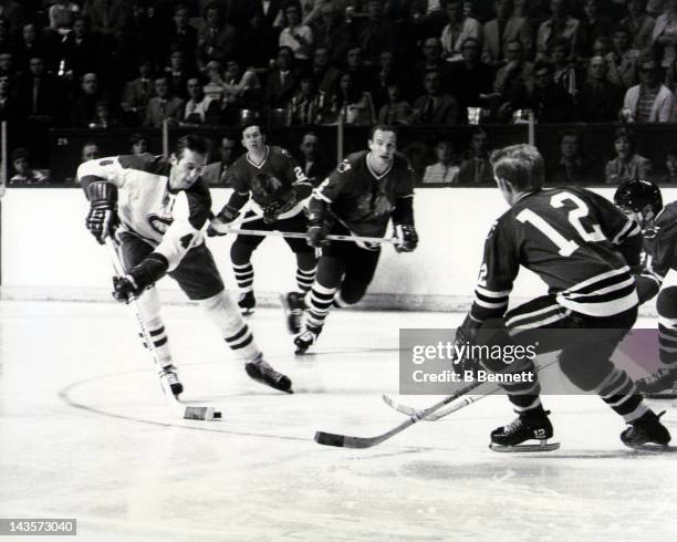 Jean Beliveau of the Montreal Canadiens skates with the puck as Bill White, Pat Stapleton and Stan Mikita of the Chicago Blackhawks defend during a...