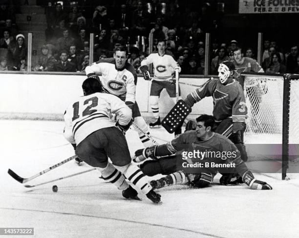 Barclay Plager and goalie Ernie Wakely of the St. Louis Blues defend the net as Yvan Cournoyer and Jean Beliveau of the Montreal Canadiens try to...
