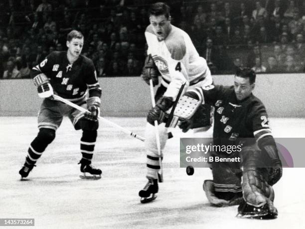 Jean Beliveau of the Montreal Canadiens tries to score on goalie Marcel Paille of the New York Rangers as his teammate Rod Seiling looks on during...