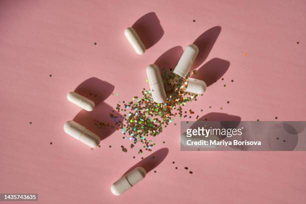 open medical capsules with glitter instead of the contents. - acid trip stock pictures, royalty-free photos & images