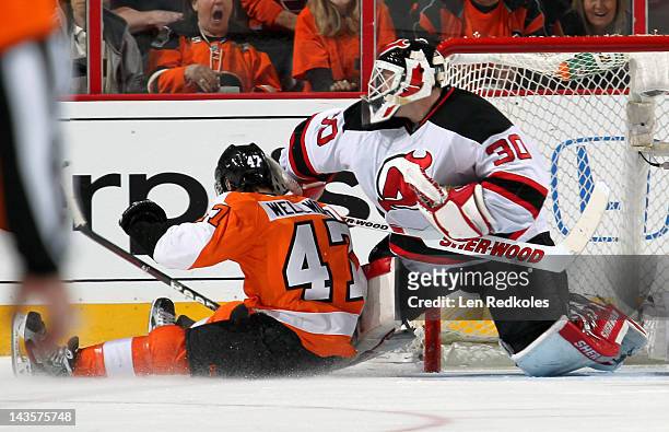 Eric Wellwood of the Philadelphia Flyers slides into goaltender Martin Brodeur of the New Jersey Devils in Game One of the Eastern Conference...