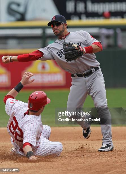 Mike Aviles of the Boston Red Sox turns a double play as Brent Morel of the Chicago White Sox slides into second at U.S. Cellular Field on April 29,...