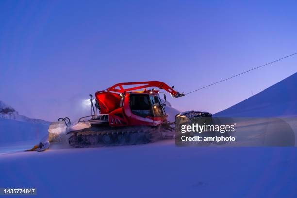 snowcat preparing ski slope in the evening - austria ski stock pictures, royalty-free photos & images