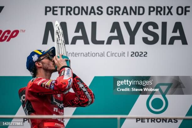 Francesco Bagnaia of Italy and Ducati Lenovo Team kisses his race winning trophy during the race of the MotoGP PETRONAS Grand Prix of Malaysia at...