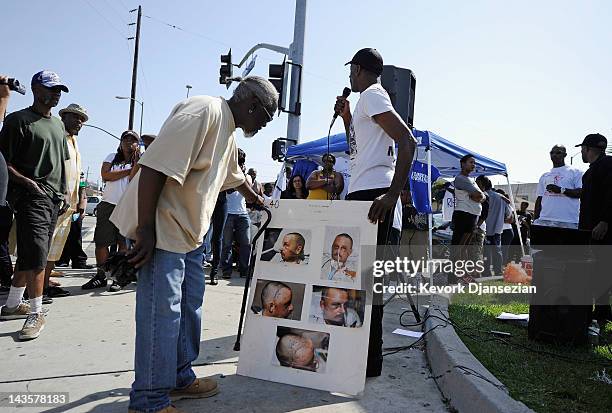 People look at hospital pictures of truck driver Reginald Denny during a rally near the intersection of Florence and Normandie Avenues in South Los...