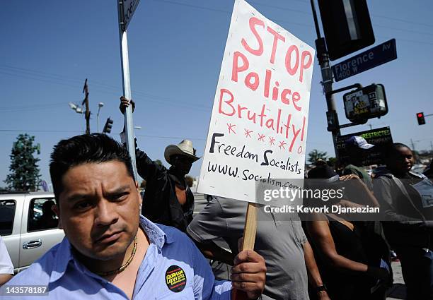 People hold a rally near the intersection of Florence and Normandie Avenues in South Los Angeles on April 29, 2012 in Los Angeles, California. This...