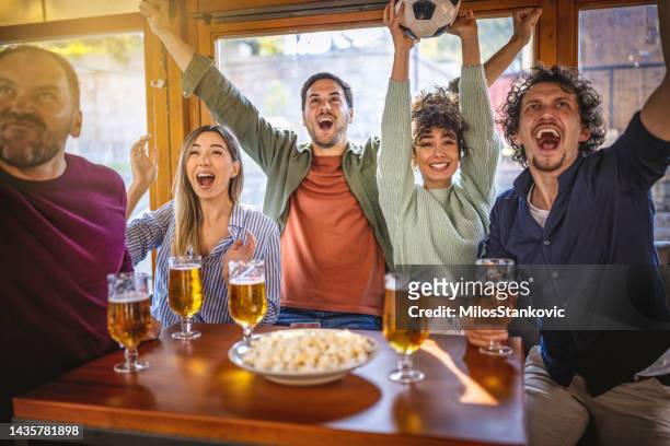 gruppo di amici che tifano per la loro squadra mentre guardano la partita in un bar - campionato mondiale di sport foto e immagini stock