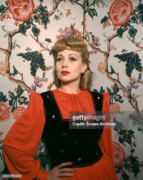 Ann Sothern posing in red and black dress circa 1944.
