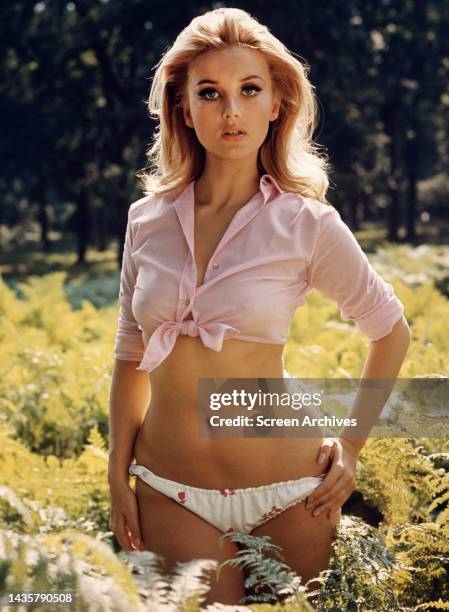 Barbara Bouchet posing in pink tank top and bikini bottoms for publicity pose for the 1967 James Bond movie Casino Royale.