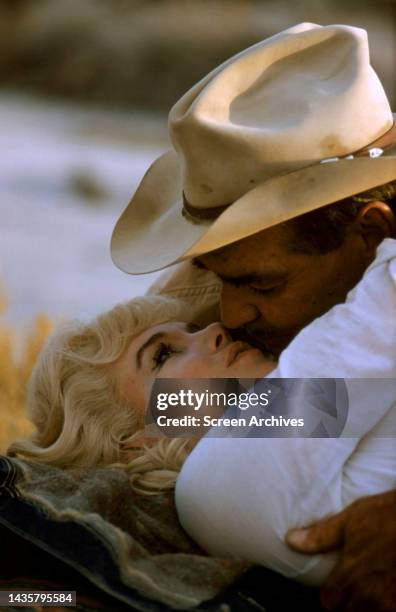 Marilyn Monroe and Clark Gable in romantic embrace, color publicity pose for the 1961 John Huston film the Misfits.