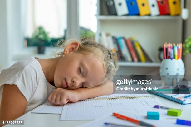 müdes mädchen schläft auf dem tisch - lernbehinderung stock-fotos und bilder