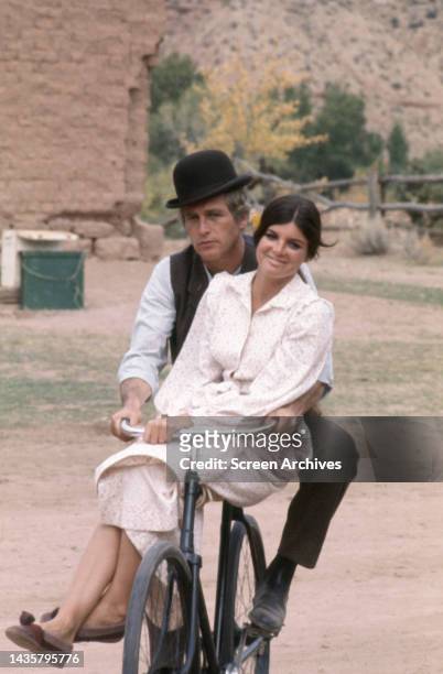 Butch Cassidy & Sundance Kid Paul Newman rides bicycle with Katharine Ross riding side saddle in a scene from the classic 1969 western.