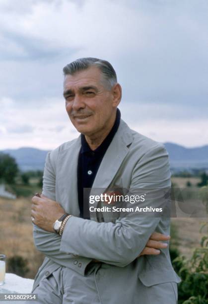 Clark Gable posing in smart grey suit on ranch circa 1959.