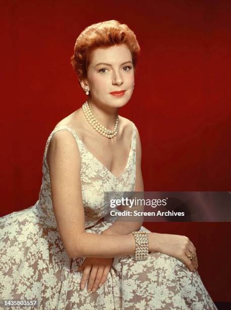 Deborah Kerr vivid color studio portrait against red backdrop circa 1956.