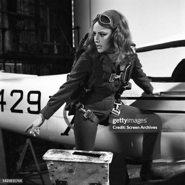 Karin Dor with parachute strapped to body standing by light aircraft in a scene from the 1967 James Bond film You Only Live Twice.