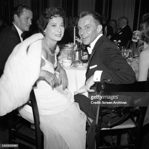 Frank Sinatra and Merle Oberon pictured at table during Hollywood event 1950's.