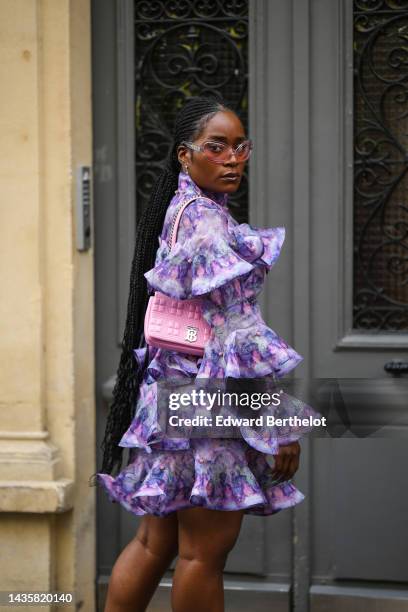 Guest wears pale pink transparent sunglasses, silver and diamonds pendant earrings, a purple and pink tie and dye print pattern turtleneck / large...