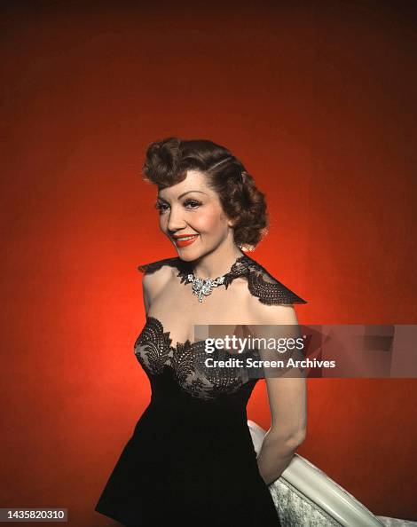 Claudette Colbert color glamour portrait in low cut evening gown ...