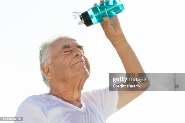 senior man pouring water - heat wave elderly stock pictures, royalty-free photos & images