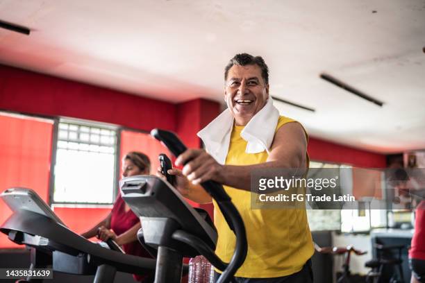 älterer mann trainiert auf einem laufband im fitnessstudio - house old bike stock-fotos und bilder