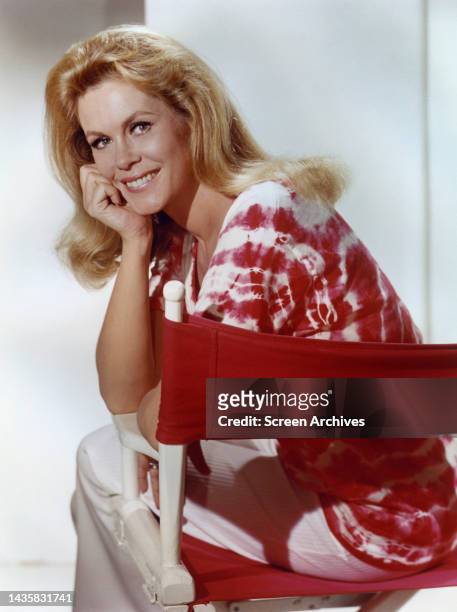 Elizabeth Montgomery smiling publicity pose in directors chain Bewitched era 1960's.