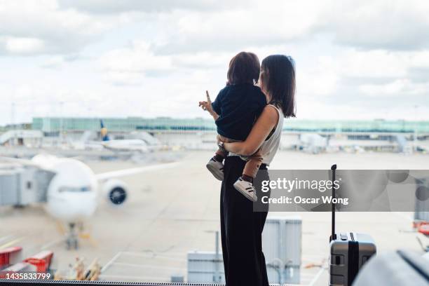 mother and toddler looking at view at the airport - sydney airport foto e immagini stock