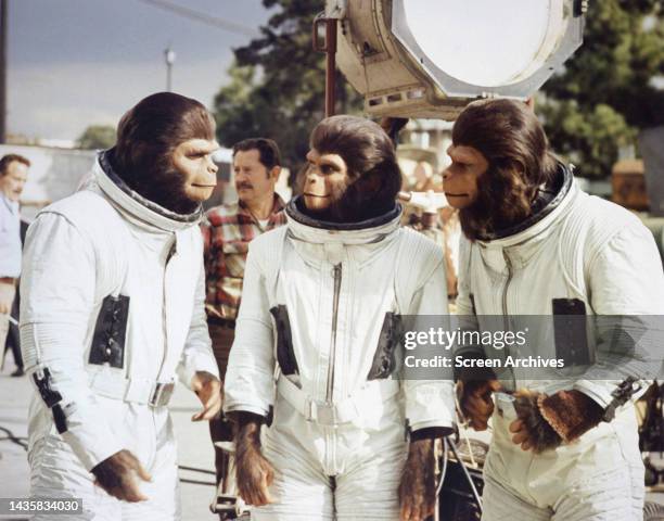 Escape from Planet of the Apes Kim Hunter, Sal Mineo and Roddy McDowall in astronaut costume and ape make up discuss scene on the set of the classic...