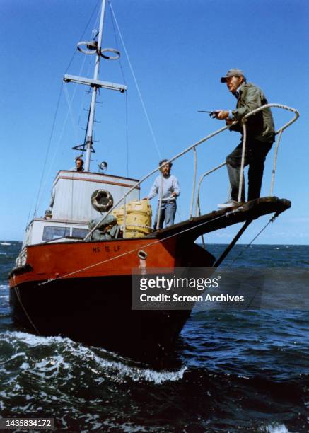 Robert Shaw with harpoon gun on boat with Richard Dreyfuss in scene from the 1974 movie 'Jaws'.