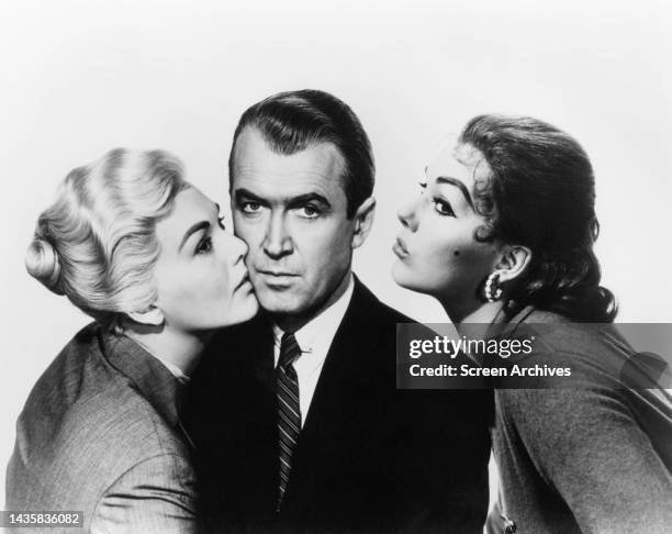 Vertigo Kim Novak as both blonde and brunette femme fatales poses either side of James Stewart in a publicity portrait for the Alfred Hitchcock...