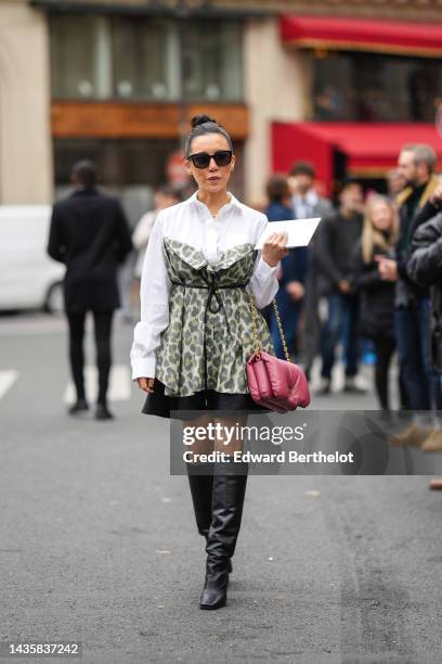 Guest wears black sunglasses, silver and gold earrings, a white shirt, a gold and diamonds necklace, a pale green with yellow and gray leopard print...