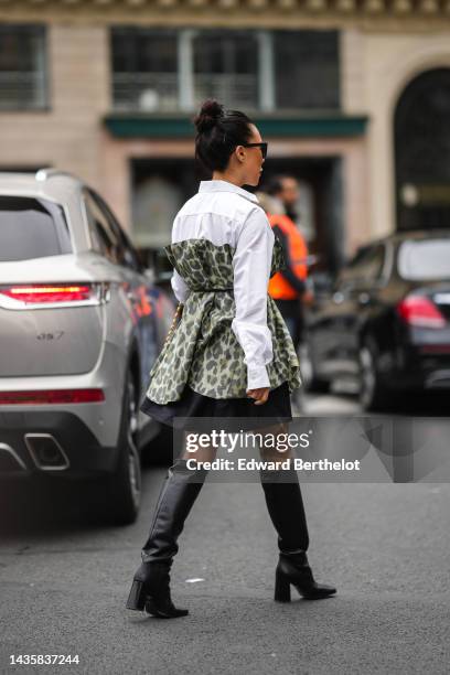 Guest wears black sunglasses, silver and gold earrings, a white shirt, a gold and diamonds necklace, a pale green with yellow and gray leopard print...