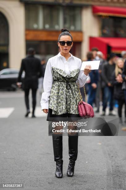 Guest wears black sunglasses, silver and gold earrings, a white shirt, a gold and diamonds necklace, a pale green with yellow and gray leopard print...