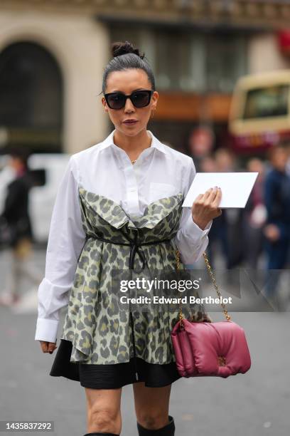 Guest wears black sunglasses, silver and gold earrings, a white shirt, a gold and diamonds necklace, a pale green with yellow and gray leopard print...