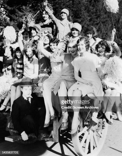 Harry Langdon poses with Hollywood Flapper Girls Pre Code in a publicity pose for the 1928 silent era comedy The Chaser.