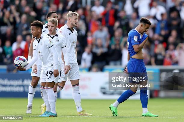 Players of Swansea City look on as Callum Robinson of Cardiff City leaves the field receiving a red card during the Sky Bet Championship between...