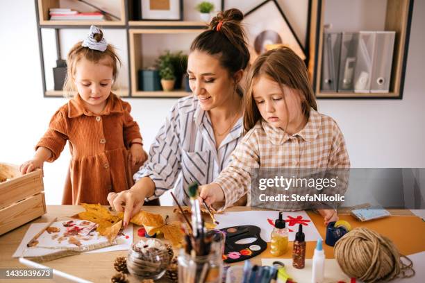 junge mutter mit kindern malen - bastelarbeit stock-fotos und bilder
