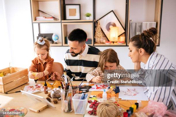 familie genießt kunst - girls around table stock-fotos und bilder