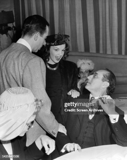 Judy Garland and Vincente Minnelli chat with Groucho Marx at Hollywood event circa 1946.