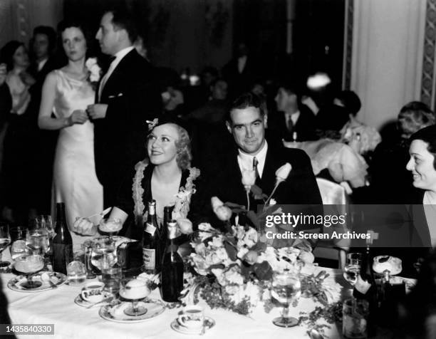 Howard Hughes and Ginger Rogers seated together at Hollywood event circa 1930's.