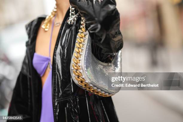 Guest wears a purple cut-out waist / shoulder-off / long dress, a black shiny varnished long oversized coat, a silver shiny leather large chain...